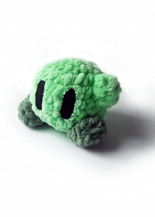 Small green kirby plush toy on a white background