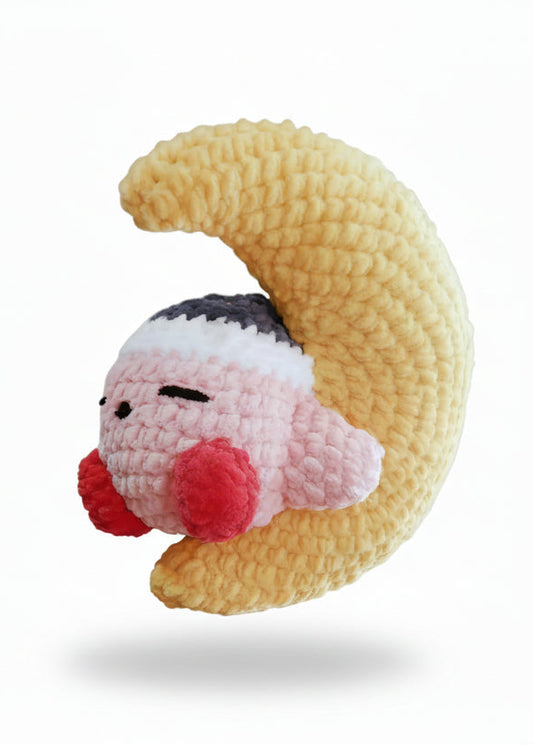 A plush toy depicting the character Kirby from Nintendo, with a beige body and red and pink accents, embroidered details, and a sleepy facial expression.