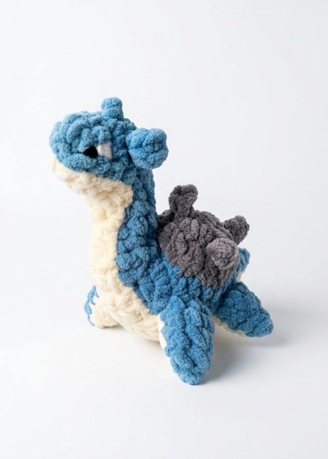 Crocheted lapras toy on a white background