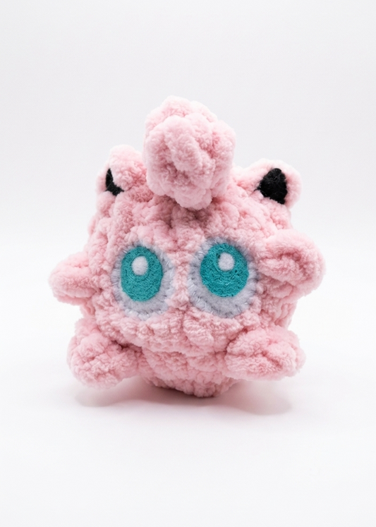 Pink plush Jiggly puff toy with teal eyes on a white background