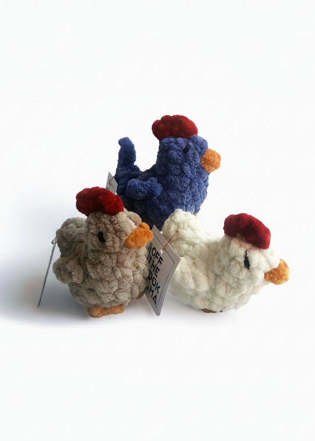 Three crocheted chicken or stardew hen toys in different colors on a white background