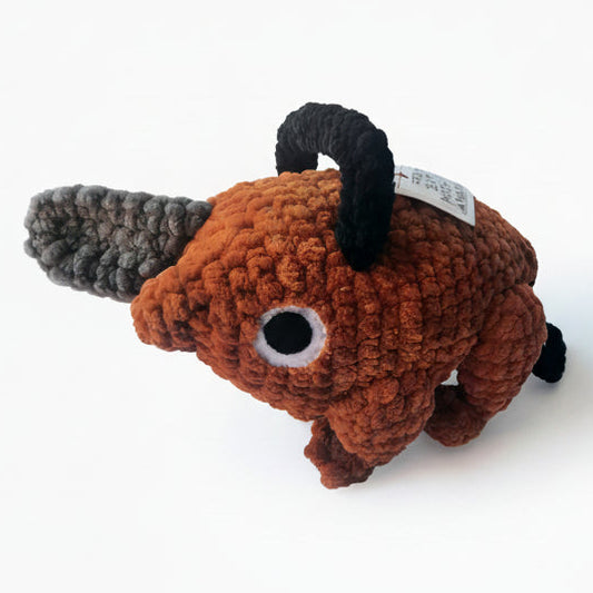 pochita from chainsaw man as lifesized amigurumi replica standing one foot tall made with super soft brown chenille yarn, grey chenille yarn for the chainsaw and black chenille for the handle stuffed with wire for rigidity. Sturdy Handmade Anime inspired plush.